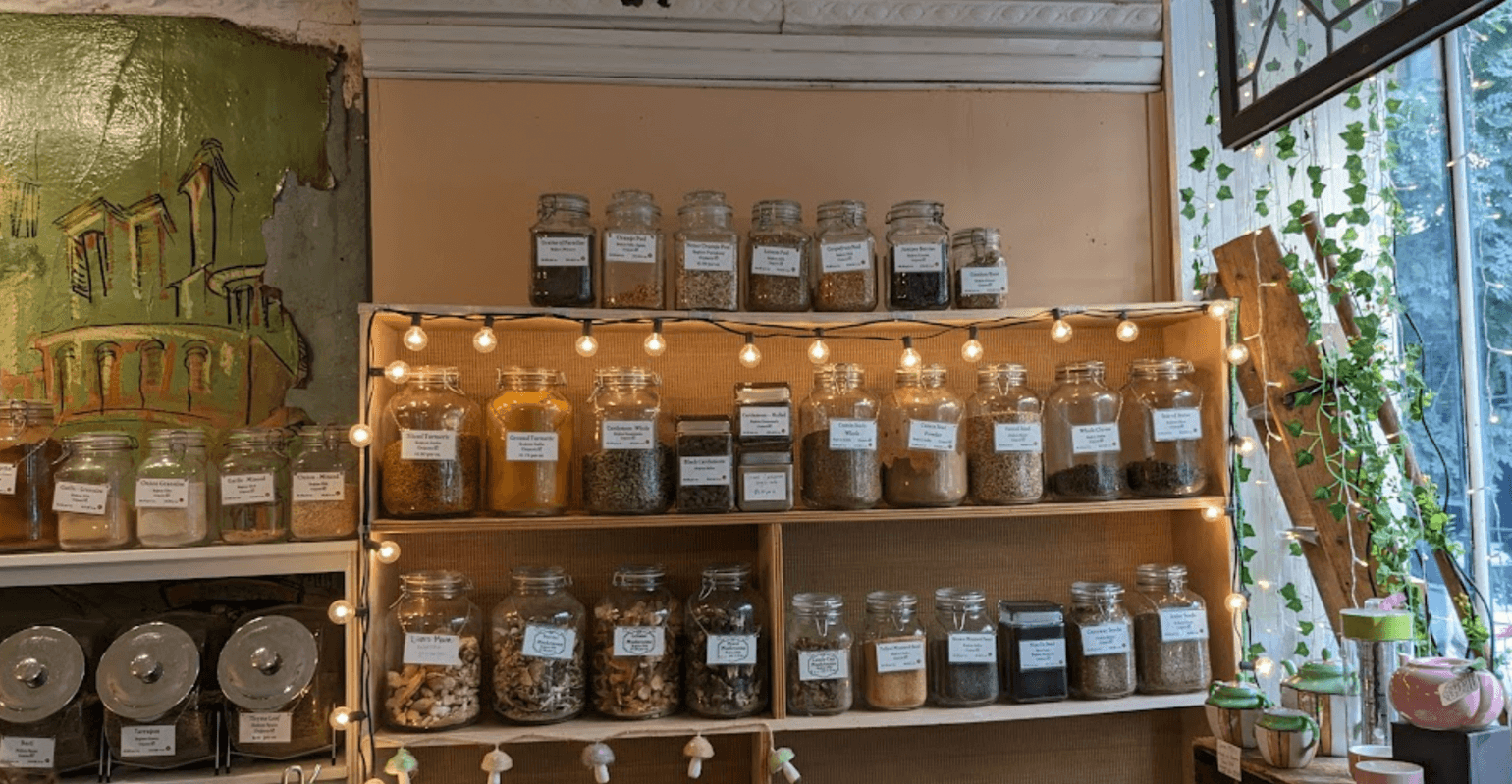 interior of a shop with jars of spices, fairy lights, and ivy vines