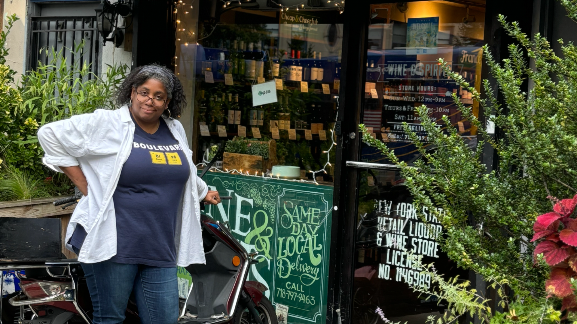 woman leaning on a moped outside a wine shop