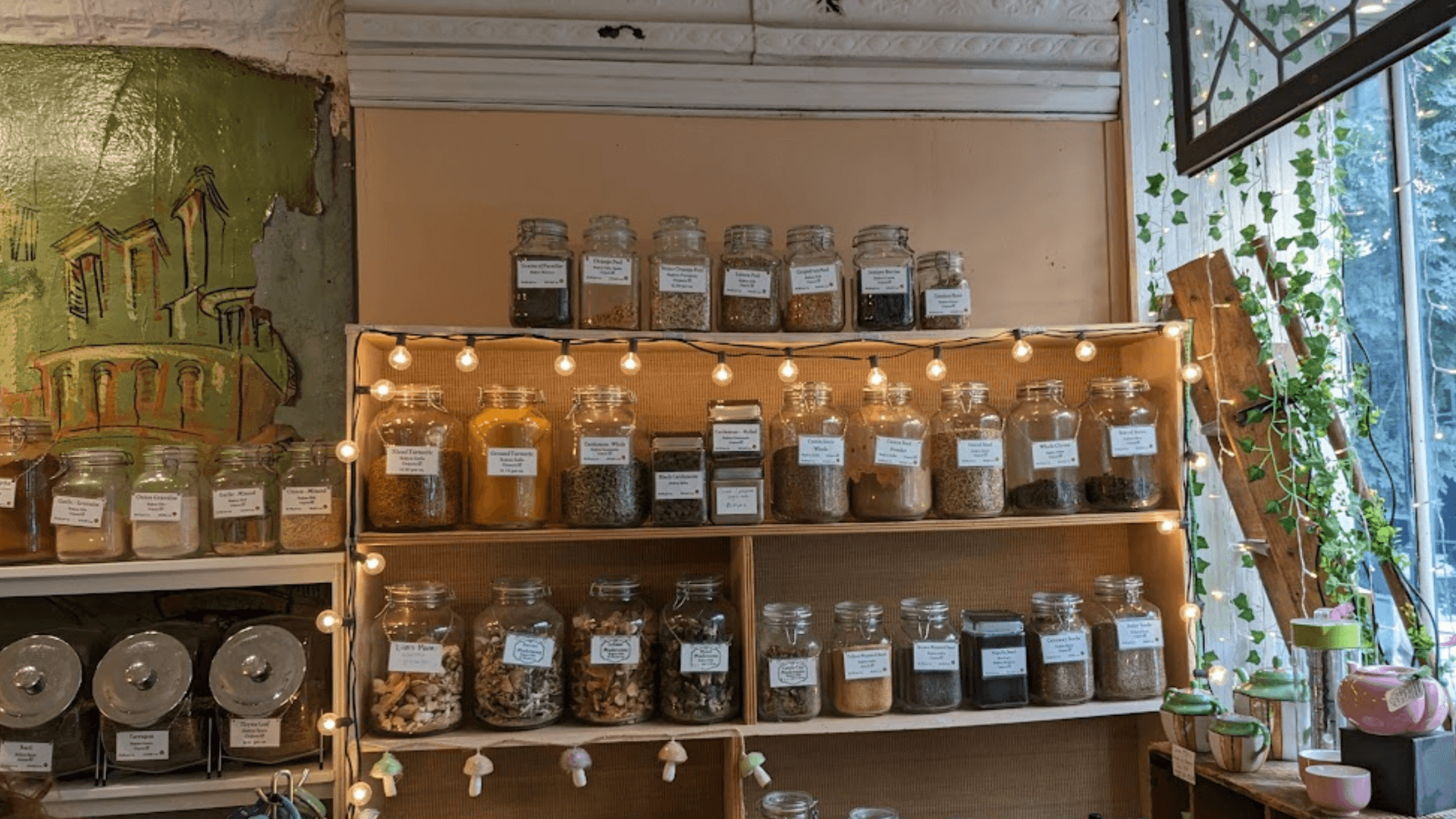 interior of a shop with jars of spices, fairy lights, and ivy vines