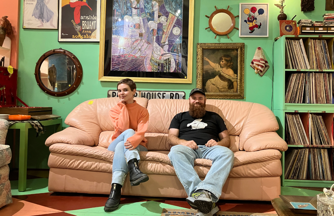 Two people sitting on a pink couch