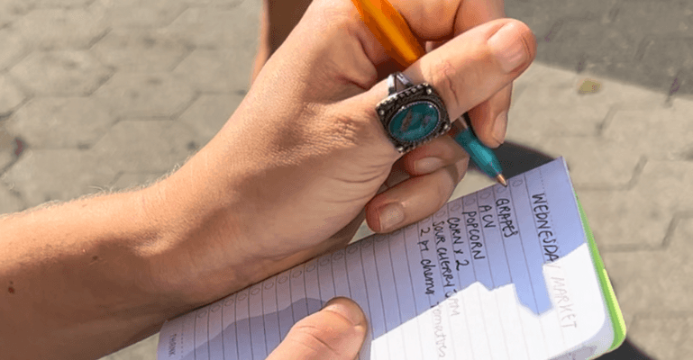 close up of a hand writing in a pocket notebook