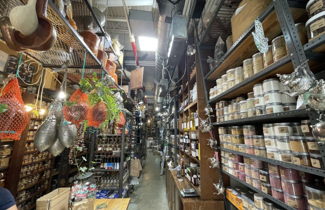 looking down a narrow aisle lined with spice containers